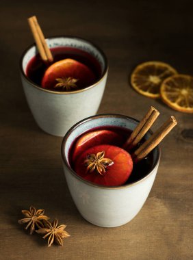 Köy masasında meyveler ve baharatlarla kırmızı şaraptan yapılmış Noel şarabı. Geleneksel sıcak kış içeceği. Yeni yıl ve Noel konsepti. Yakın plan..