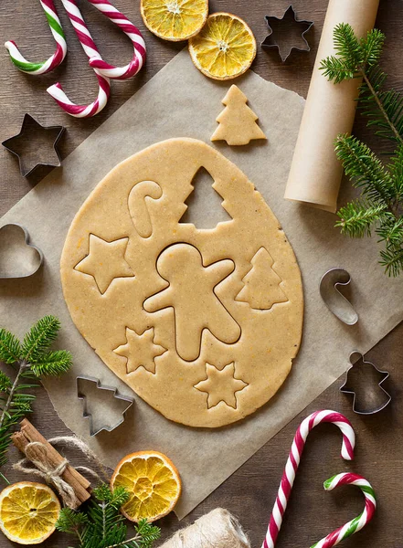 用生面团做生姜饼干 用特殊的金属模子切饼干 形状像星星 圣诞树 一个男人 干橙子 圣诞糖果 云杉树枝 顶部视图 — 图库照片