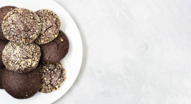 Ev yapımı çikolatalı kurabiyeler ve beyaz bir tabakta ceviz. Uzayı kopyala Üst Manzara. Yakın plan..