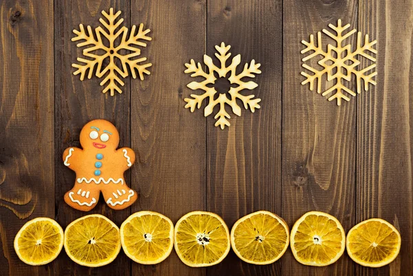 一个人的姜饼 木制雪花和一片褐色木制背景的干橙子 圣诞节的背景平躺在床上复制空间 — 图库照片
