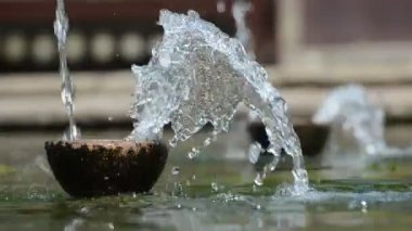 Fountain tabakta su akar. Su damlacıkları dağılım farklı yönlere.