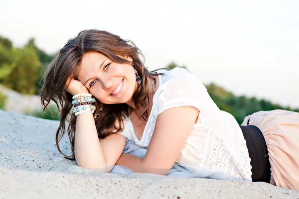 Chica sonriente con ojos azules en la arena — Foto de Stock