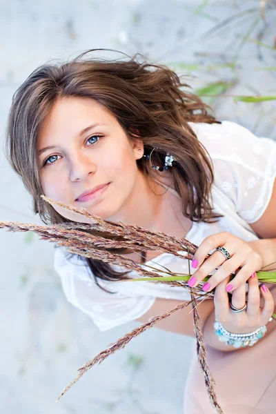 Chica sonriente con ojos azules en la arena — Foto de Stock