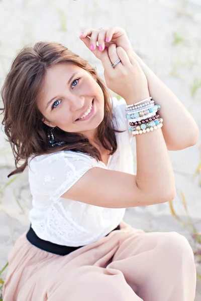 Chica sonriente con ojos azules en la arena — Foto de Stock