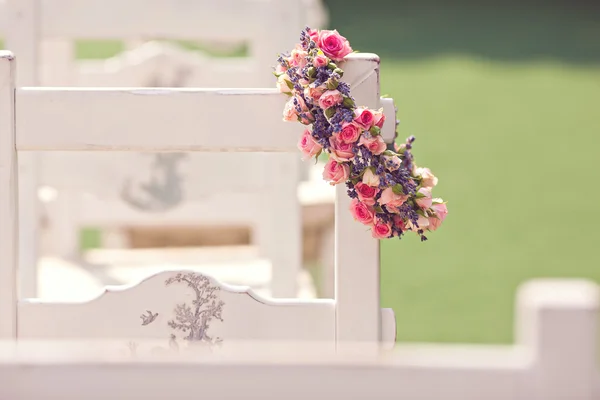 Sillas de ceremonia de boda y una corona de rosas — Foto de Stock