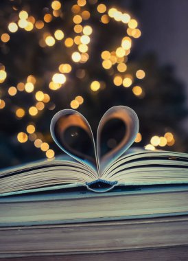 Bokeh arka planda kalp şeklinde bir kağıt kitap. Sevgililer Günü. aşk sembolü