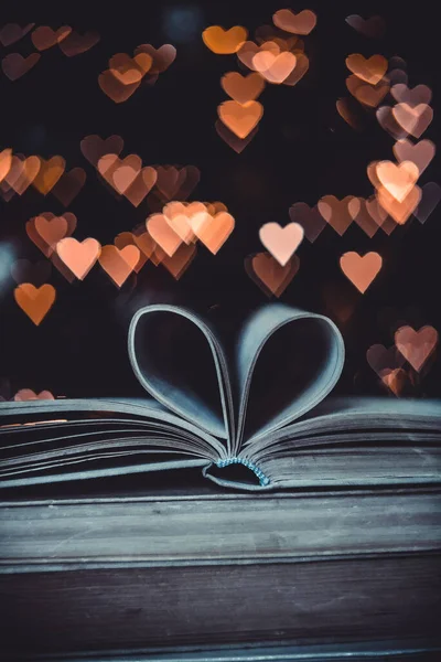 Paper book in the shape of a heart on the background of bokeh hearts. valentine\'s day concept.love symbol