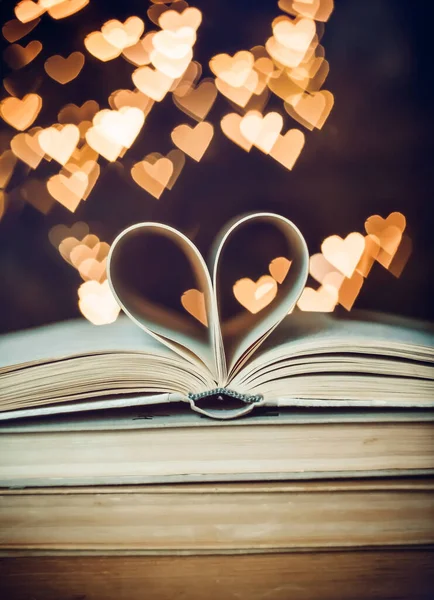 Paper book in the shape of a heart on the background of bokeh hearts. valentine\'s day concept.love symbol