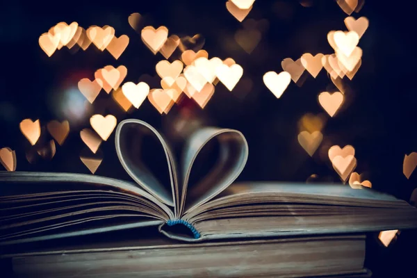 Paper book in the shape of a heart on the background of bokeh hearts. valentine\'s day concept.love symbol