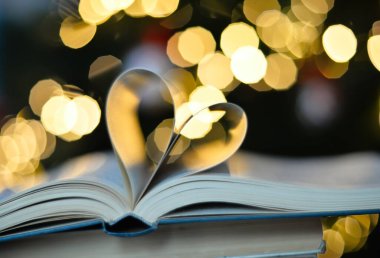 Heart from book pages love concept on heart bokeh background. VALENTİN GÜNÜ