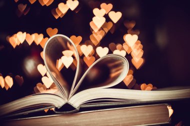 Heart from book pages love concept on heart bokeh background. VALENTİN GÜNÜ