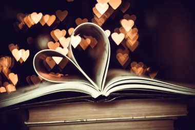 Heart from book pages love concept on heart bokeh background. VALENTİN GÜNÜ