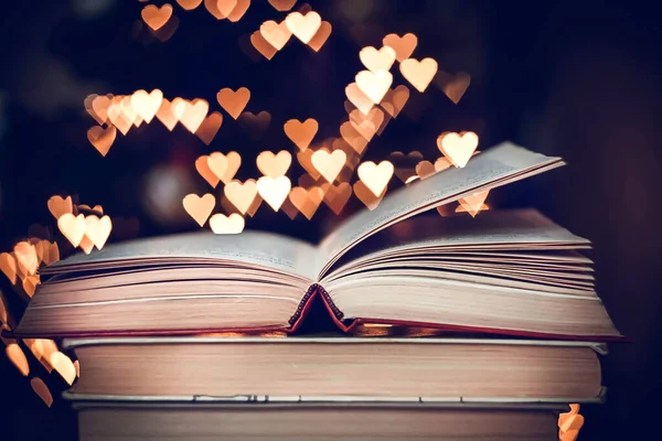 バックグラウンドにはレトロなスタイルの本やボケの心の光のスタック バレンタインデーのコンセプト ロイヤリティフリーのストック画像