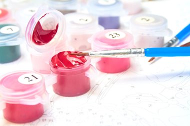 Resimler için suluboya boya kavanozlarını ve fırçaları arkaplandaki rakamlarla numaralandırın.