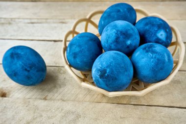 Ahşap arka planda mavi boyalı yumurtalar.