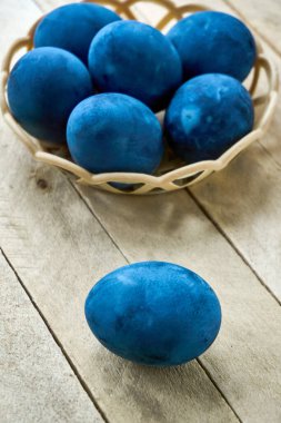 Ahşap arka planda mavi renkli yumurtalar, dikey çekim, dikey yönelim.