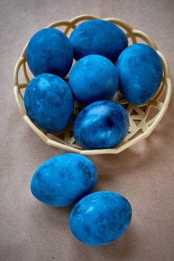 Kağıt arka planda mavi boyalı yumurtalar.
