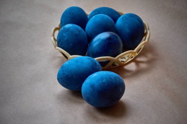 Kağıt arka planda mavi boyalı yumurtalar.