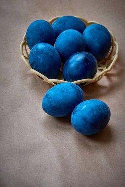 Kağıt arka planda mavi boyalı yumurtalar.