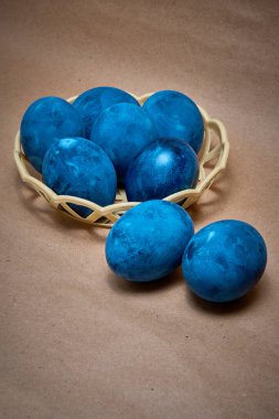 Kağıt arka planda mavi boyalı yumurtalar.