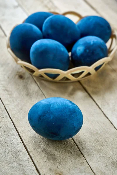 Ahşap arka planda mavi renkli yumurtalar, dikey çekim, dikey yönelim.