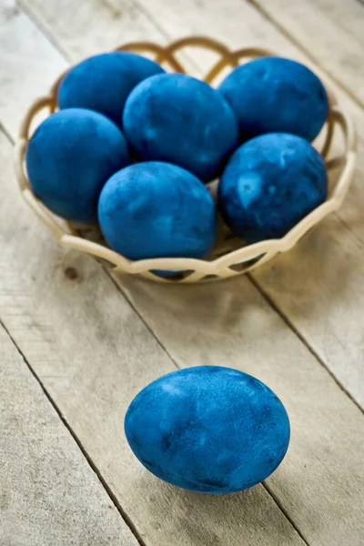Ahşap arka planda mavi renkli yumurtalar, dikey çekim, dikey yönelim.
