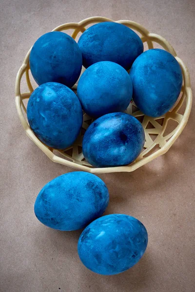 Kağıt arka planda mavi boyalı yumurtalar.