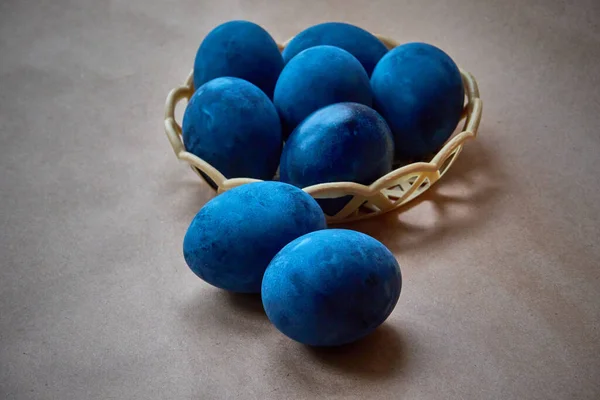 Kağıt arka planda mavi boyalı yumurtalar.