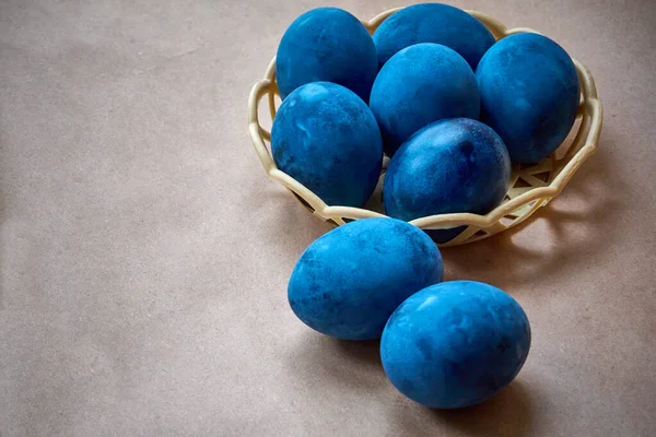 Blue painted eggs on a paper background.
