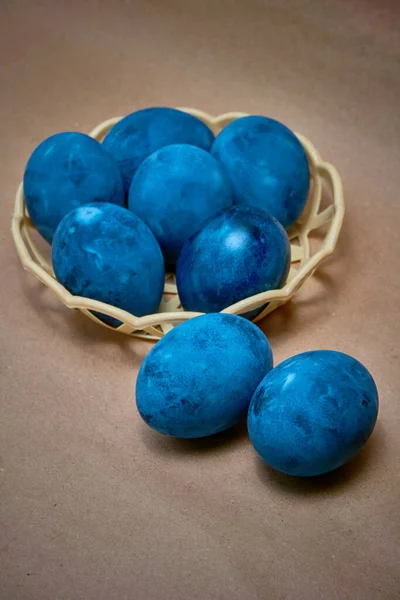 Kağıt arka planda mavi boyalı yumurtalar.
