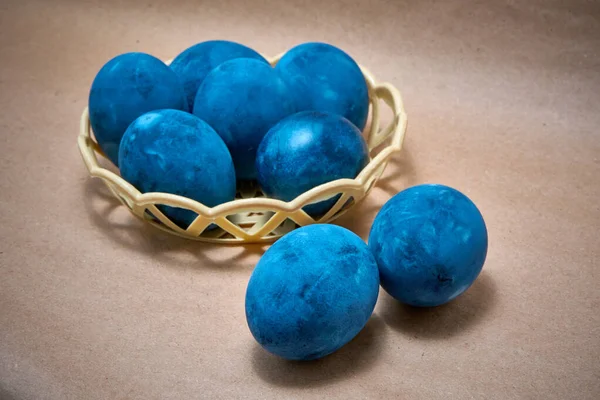 Kağıt arka planda mavi boyalı yumurtalar.