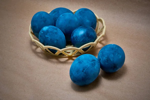 Kağıt arka planda mavi boyalı yumurtalar.