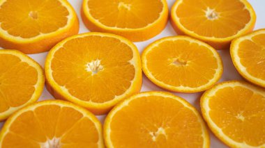 Perfectly sliced oranges on a gray plate. Half rings of oranges on plate. Saturated oranges are sliced on a plate clipart