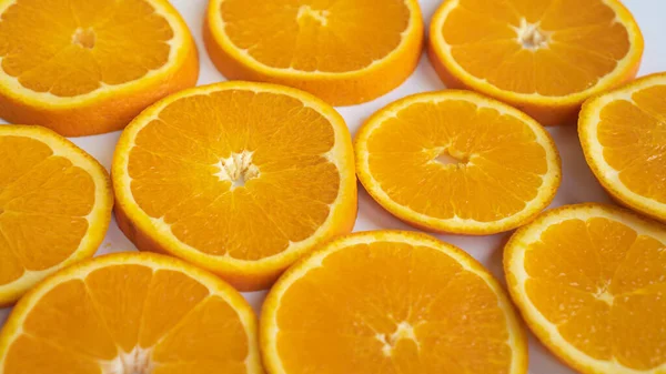 Perfect gesneden sinaasappels op een grijs bord. Halve ringen sinaasappels op het bord. Verzadigde sinaasappelen worden op een bord gesneden Stockfoto