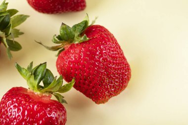 Sarı arka planda çilekler. Böğürtlen örneği. Büyük çilekler.