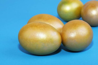Mavi arka planda altın Paskalya yumurtaları. Paskalya arkaplanı