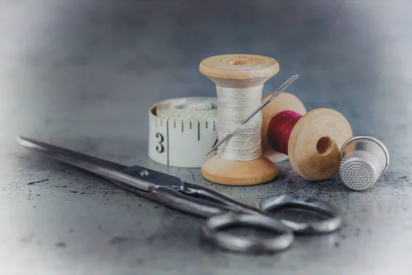 木製のスプールで多色の糸 はさみで針を縫い 古い表面にテーラーメイドのテープ 糸の背景を縫う レトロなスタイル — ストック写真