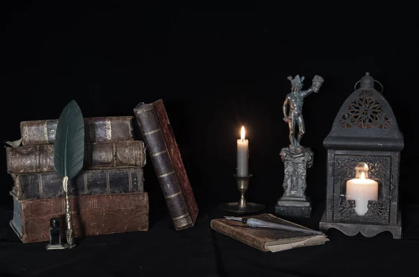 오래 된 책 과 촛불 옆에 있는 메두사 상. — 스톡 사진