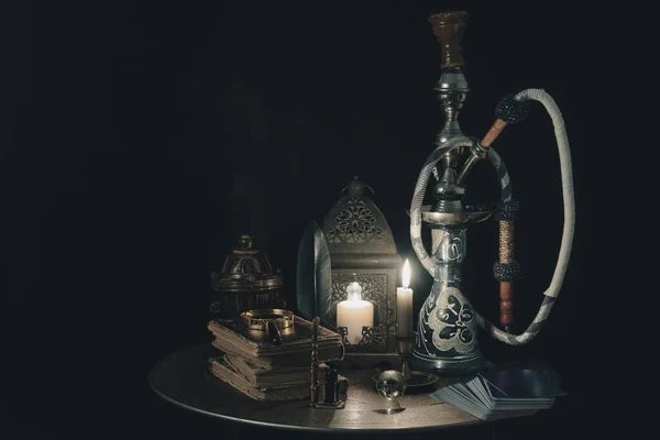 Shisha hookah wraz z książką ze świecami. Koncepcja shisha. — Zdjęcie stockowe