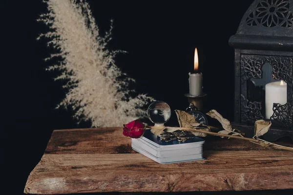Dark wallpaper romantic scene of books, candles and mystery. Night of tarot card pulling.
