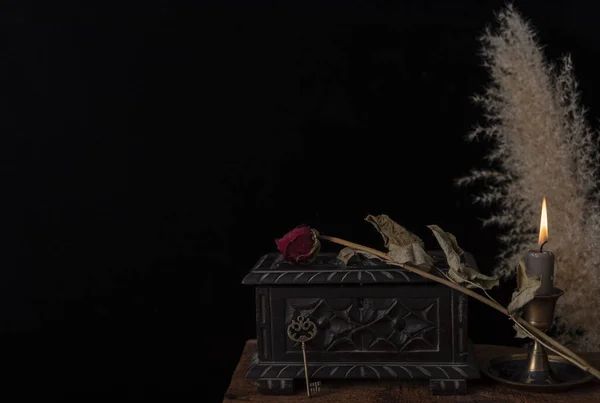 Dark still life with dried roses on wooden table. — Stock Photo, Image