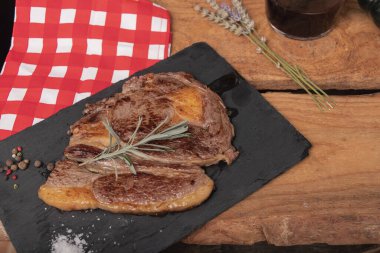 Pizarra kabında çiğ biftek, siyah arka planda izole edilmiş..