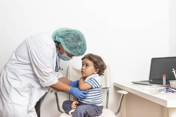 小児科医は診療所で金髪の白人の子供のための幼児ワクチンを準備します. — ストック写真