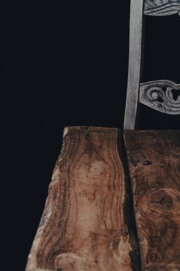 Dumanlı boş ahşap masa koyu arkaplanda süzülür.