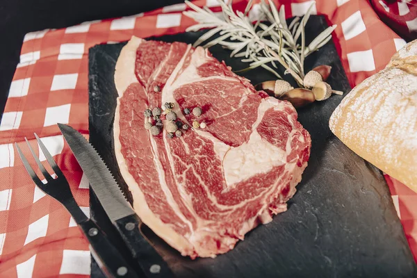 Raw beef filet mignon steak rozmaringgal, borssal és sóval sötét rusztikus lapon, fekete angus hússal. — Stock Fotó
