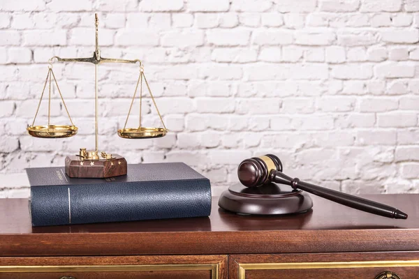 Wagi wymiaru sprawiedliwości z książkami prawniczymi na stole notariusza urzędującego. — Zdjęcie stockowe