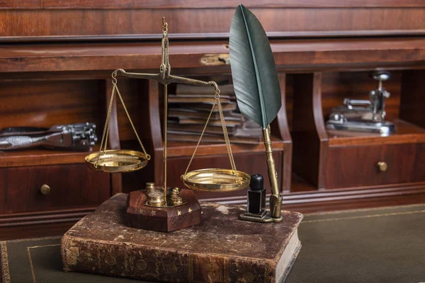 Κλίμακα της δικαιοσύνης με νομικά βιβλία στο τραπέζι του συμβολαιογράφου στο γραφείο. — Φωτογραφία Αρχείου
