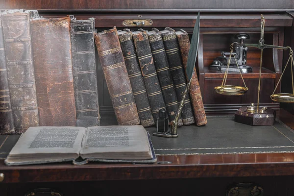 Παλιά στυλό πένα, βιβλία και vintage μελανοδοχείο σε ξύλινο γραφείο στο παλιό γραφείο κατά το υπόβαθρο της η βιβλιοθήκη και οι ακτίνες του φωτός. Εννοιολογικό υπόβαθρο για την ιστορία, εκπαίδευση, θέματα λογοτεχνίας. — Φωτογραφία Αρχείου
