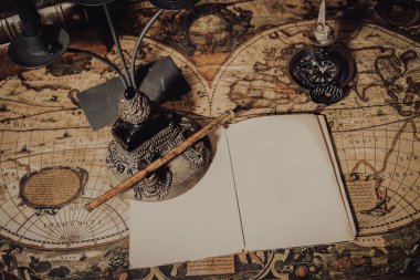 Kopya alanı olan eski bir duvar kağıdı. Mürekkep hokkası ve kalem ile bir plan üzerine kitap yazan antik masa..