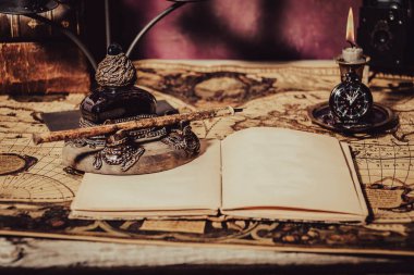 Vintage wallpaper with copy space. Antique desk with inkwell and pen writing a book on a blueprint.